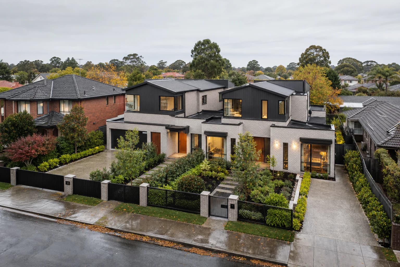 A newly built pair of two-storey contemporary homes sharing one block, next door to an original single-storey brick and tile house