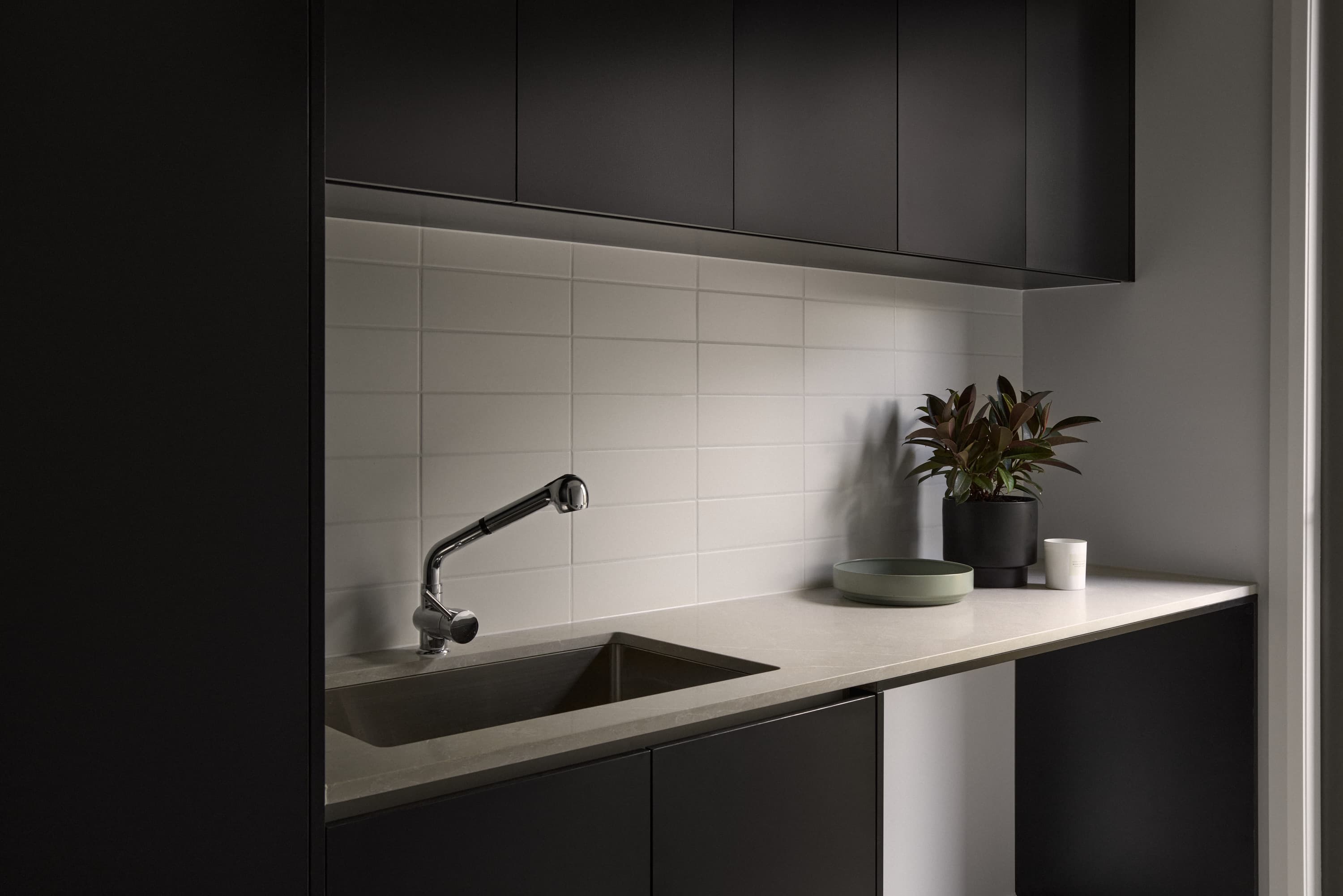 Sink and benchtop with dark cabinetry and tiled splashback, custom home near Officer
