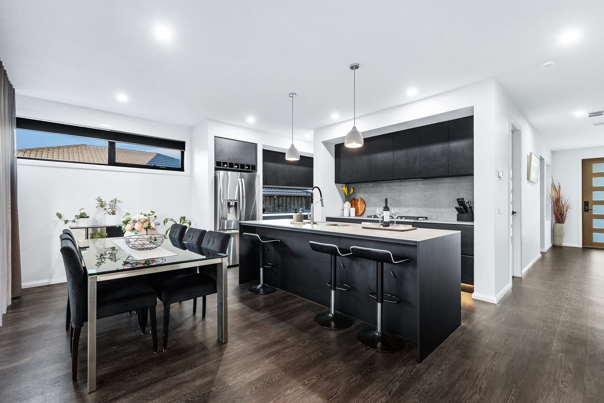 The Obsidian, dark kitchen and dining with black bar stools