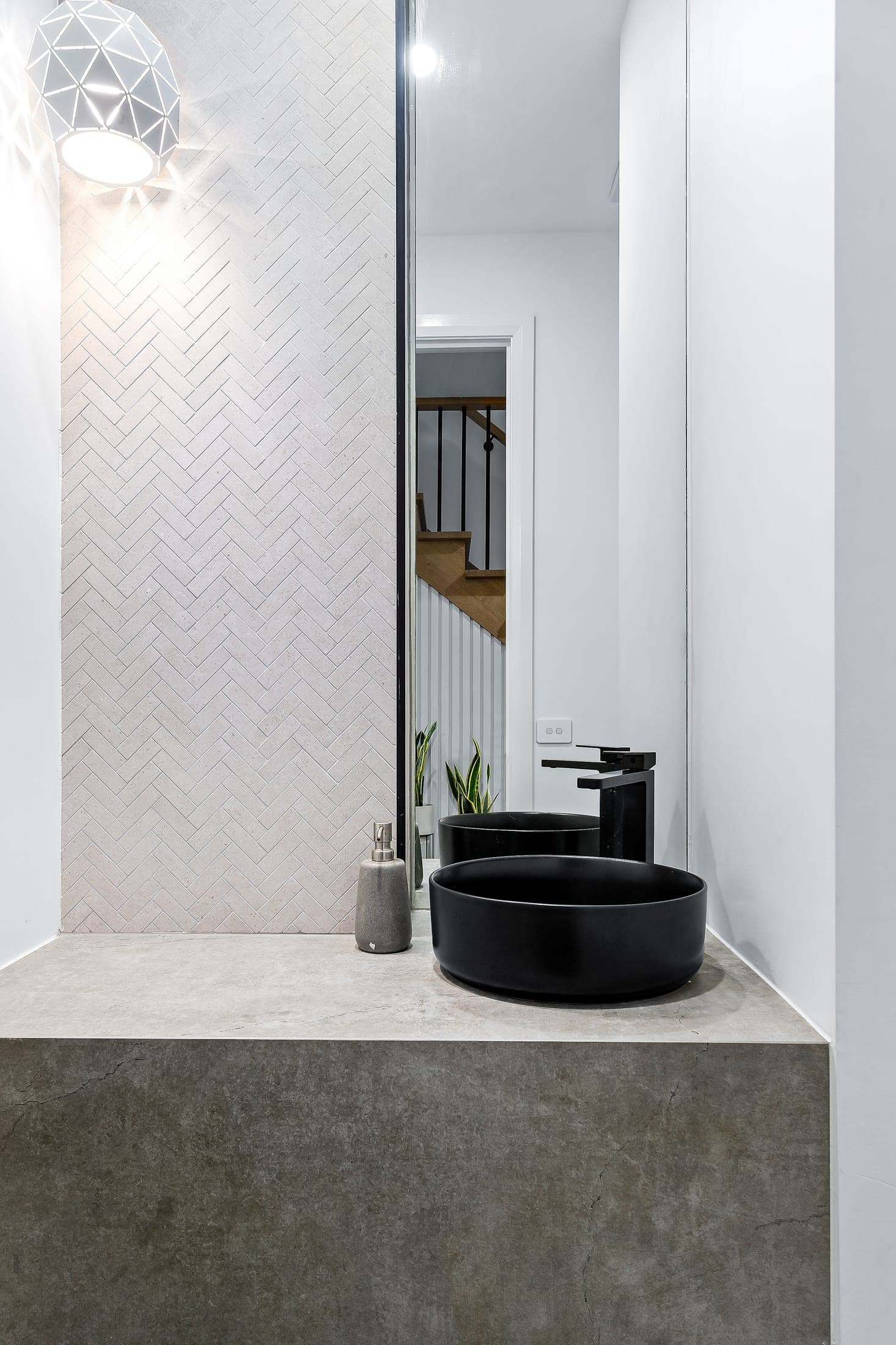 Herringbone-tiled powder room with twin black basins, NE Homes development