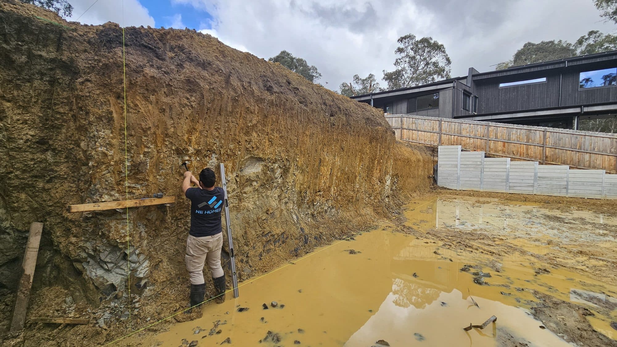 Deep excavation cut face on a sloping Warrandyte block, with clay over weathered rock