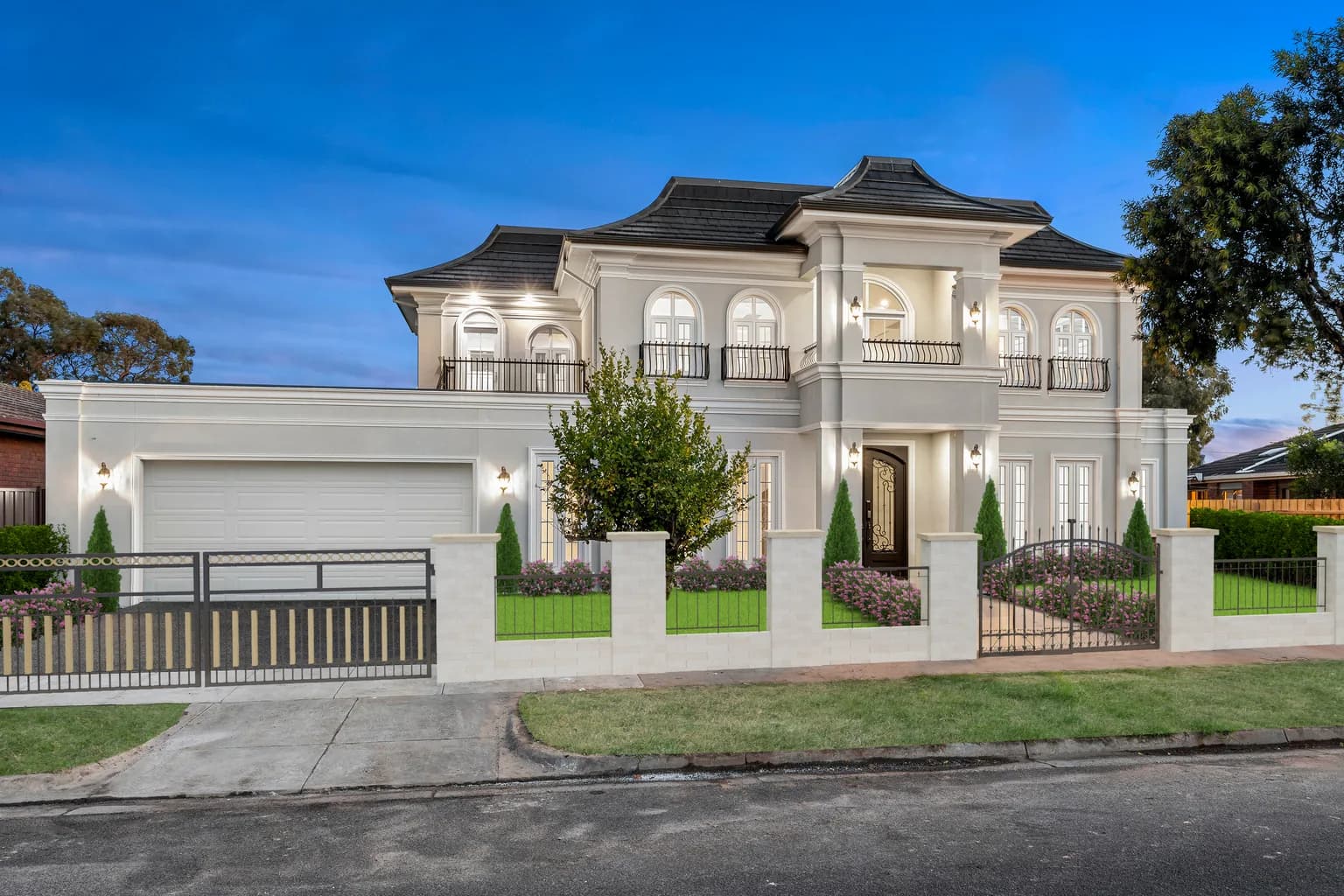 The Marquise, a two storey French provincial custom home by NE Homes in Oakleigh South, at dusk